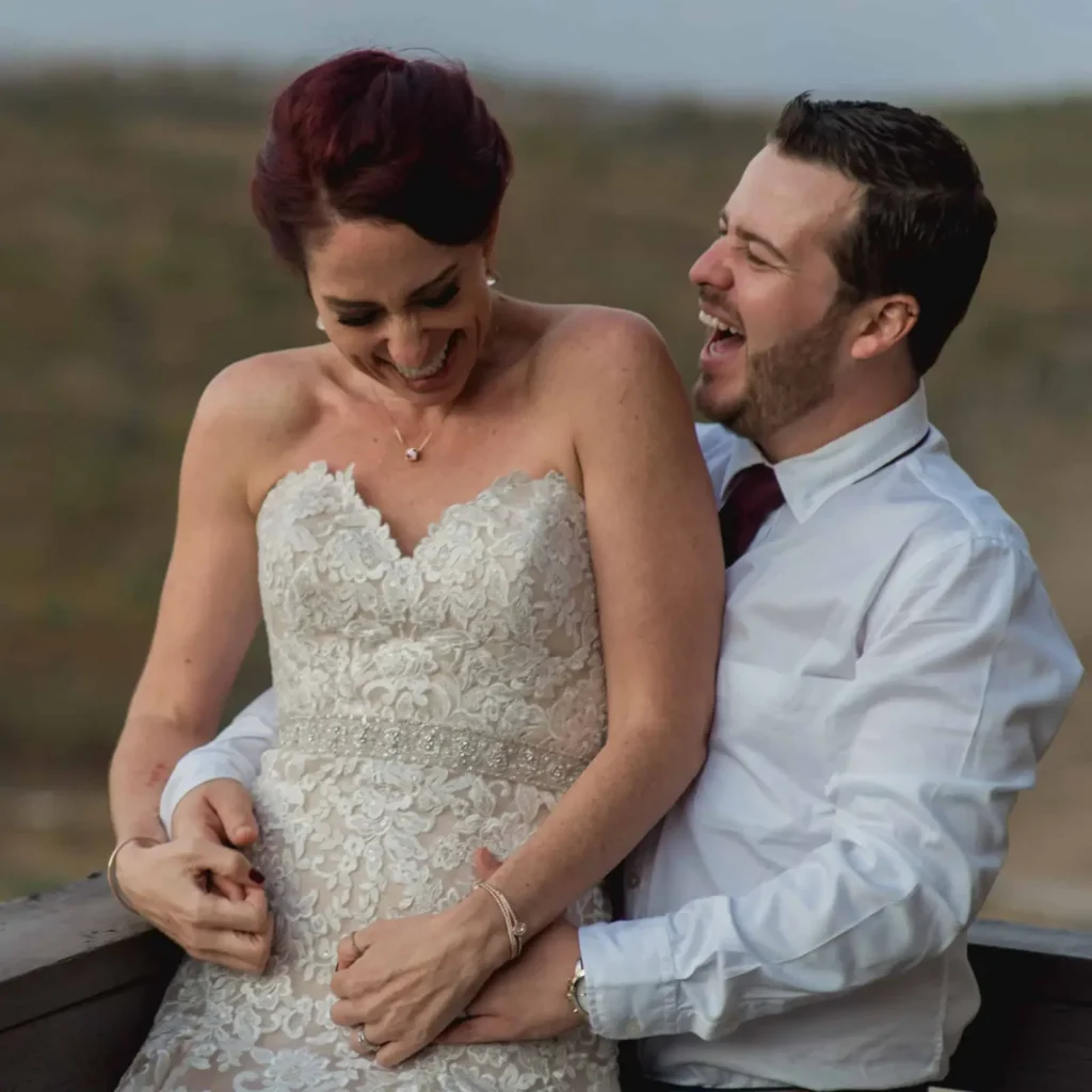 Bride laughing in her groom's arms